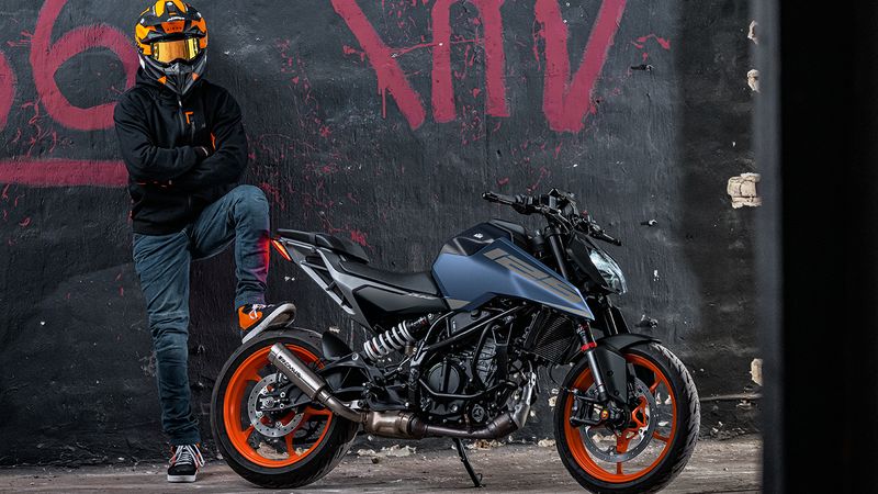 Moto légère KTM 125 Duke à l'arrêt, avec son pilote